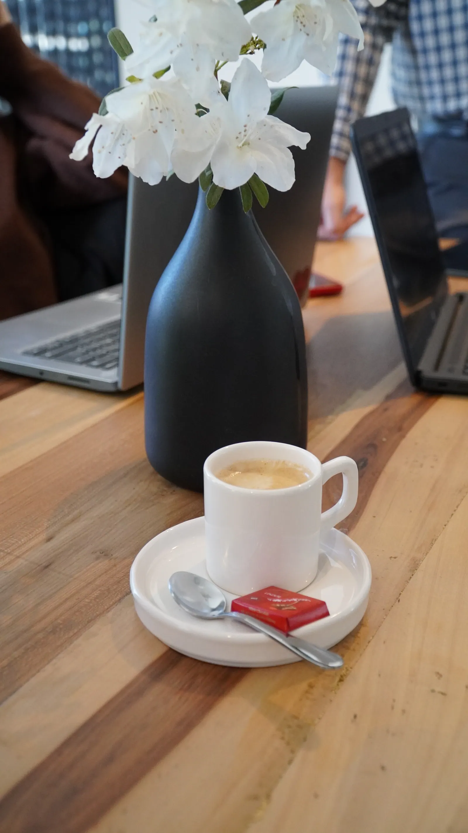 Un café y flores sobre una mesa de la oficina