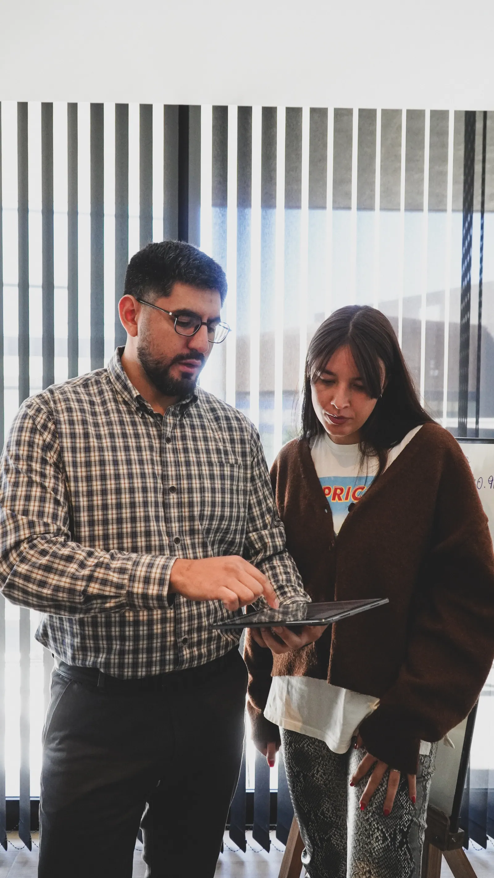 Dos integrantes del equipo conversan frente a una tablet