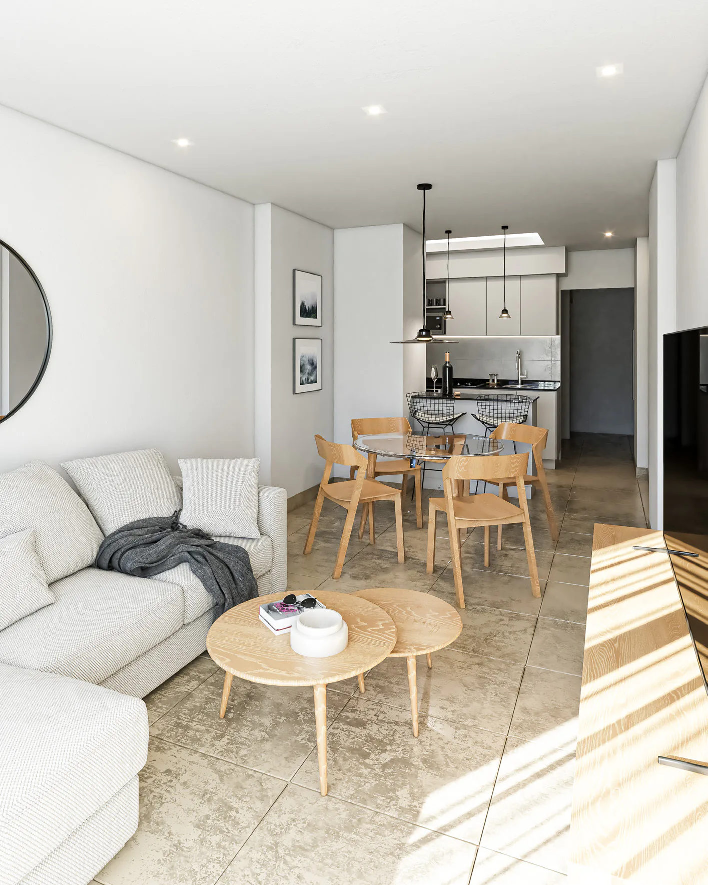 Monoambiente con sillón blanco y mesas ratonas redondas en primer plano, mesa con sillas de madera y cocina blanca al fondo