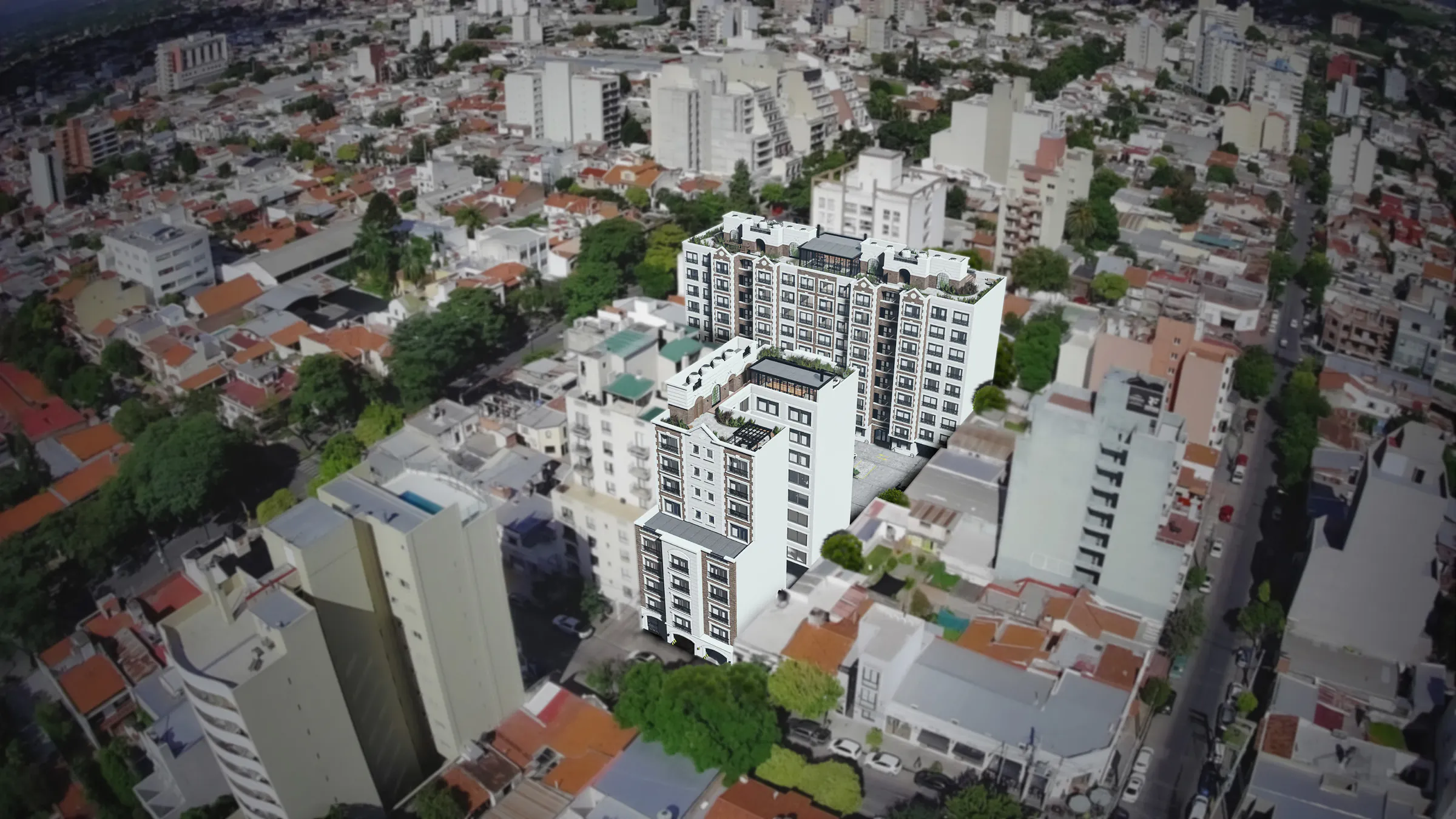 Vista aérea del conjunto: las tres torres blancas en el centro de una manzana, rodeadas de casas bajas con techos de chapa y teja, árboles y edificios de altura media