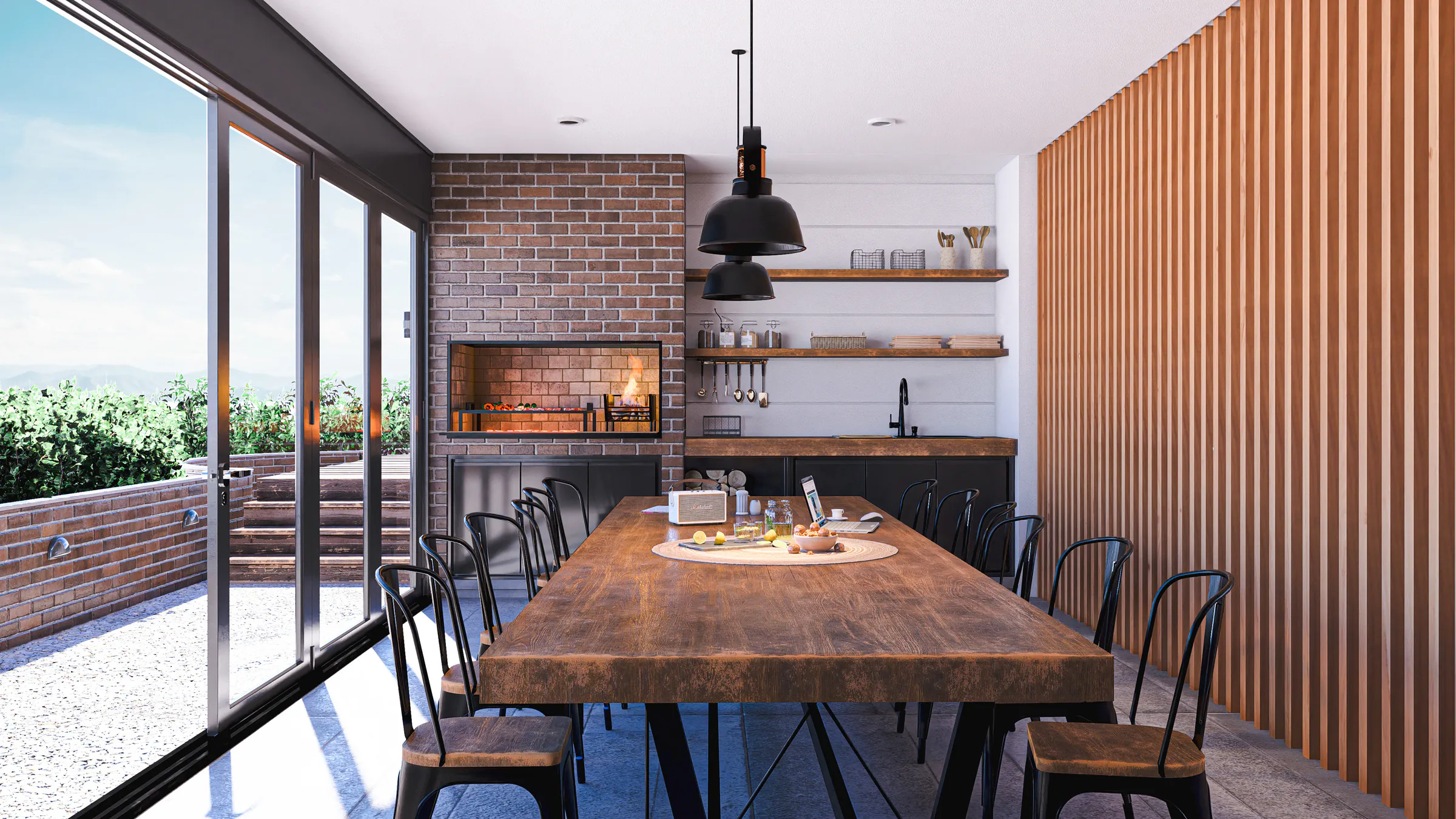 Espacio con parrilla de ladrillo, mesa larga de madera con sillas negras, lámparas colgantes, pared de listones de madera y puertas vidriadas a una terraza con plantas