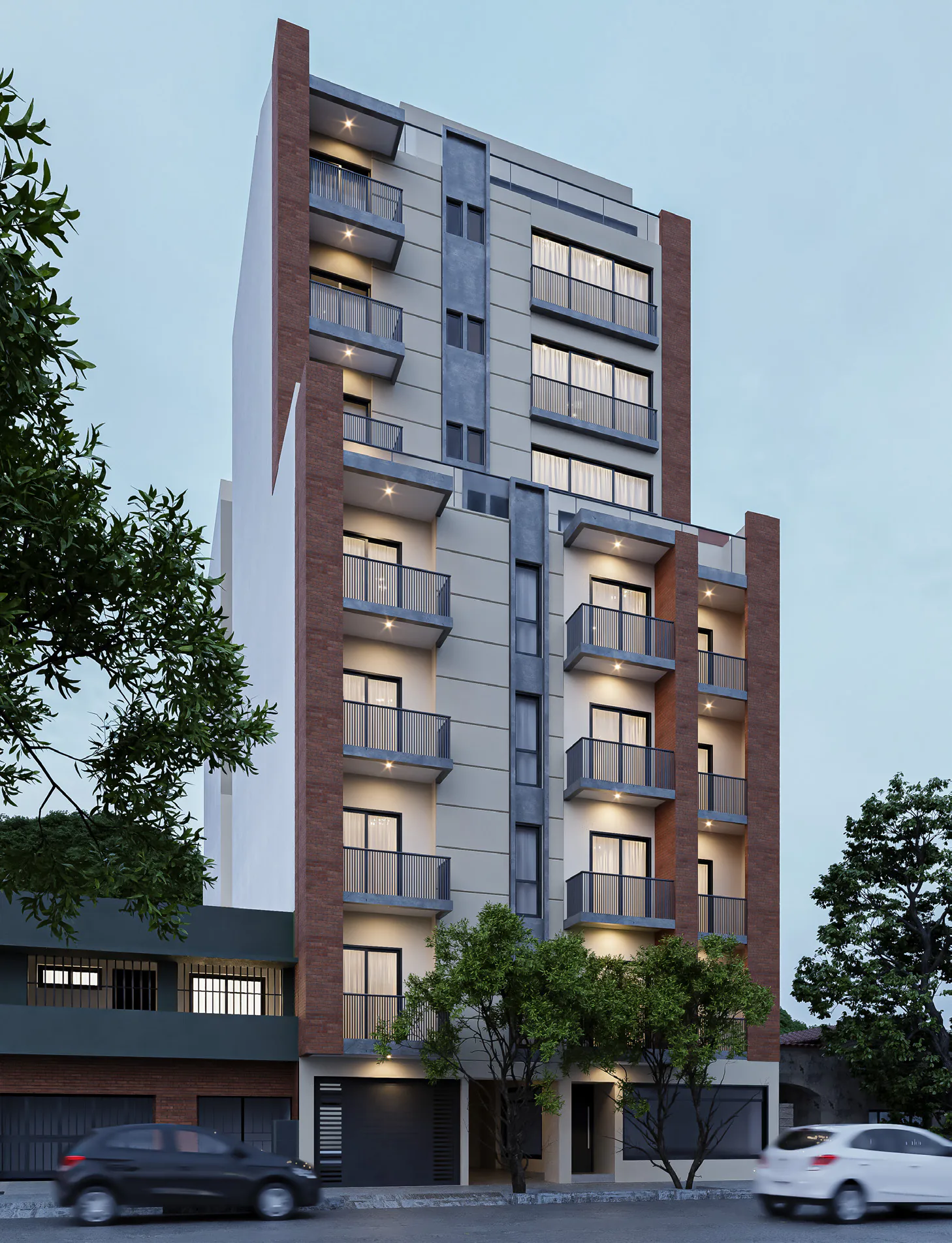 Render al anochecer de V954 desde la vereda de enfrente: edificio de balcones con barandas de vidrio, paños grises y pilastras de ladrillo, ventanas iluminadas, árboles en la vereda y autos estacionados